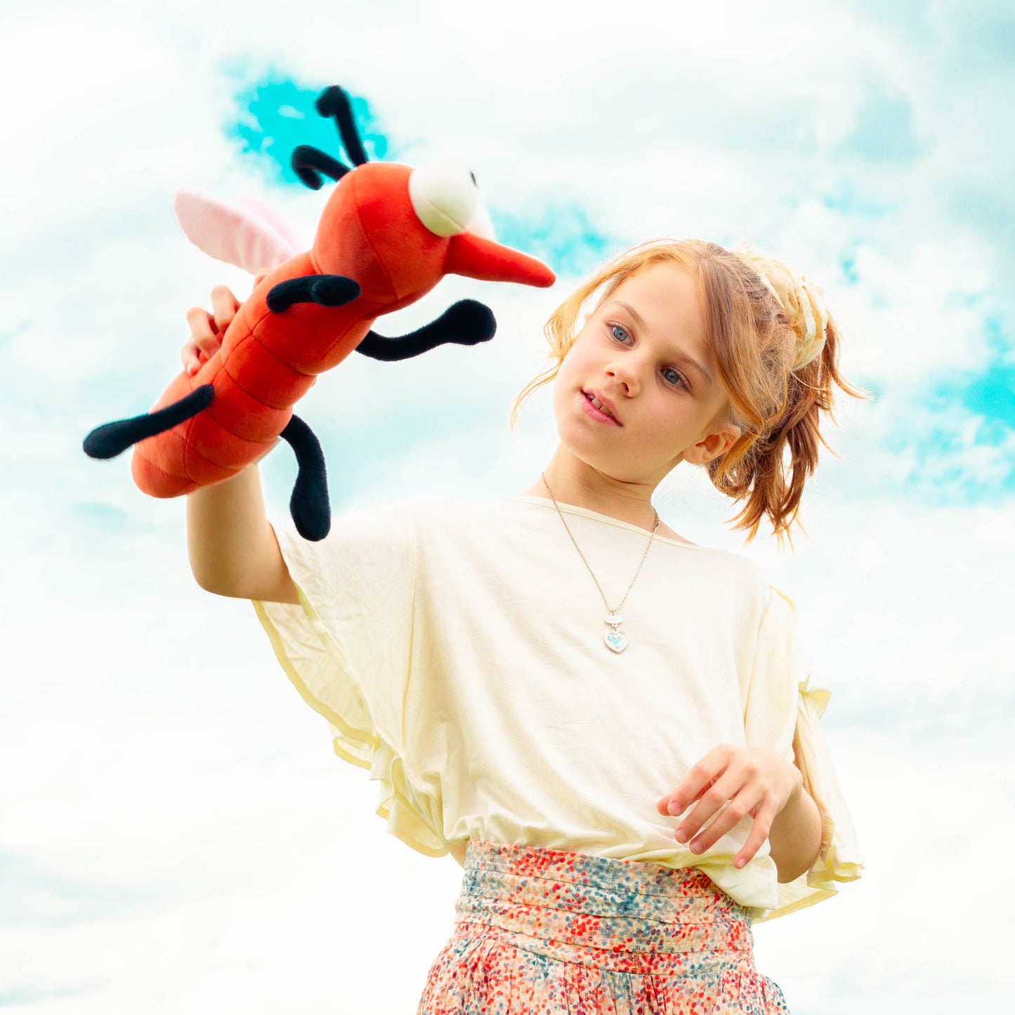 Mädchen spielt mit der Plüschmücke in groß.