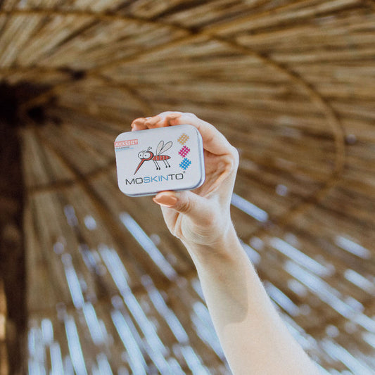 Moskinto Familiendose in der Hand einer Frau im Urlaub am Strand.