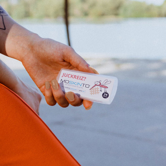 Frau hält Schiebebox in der Hand am Strand.