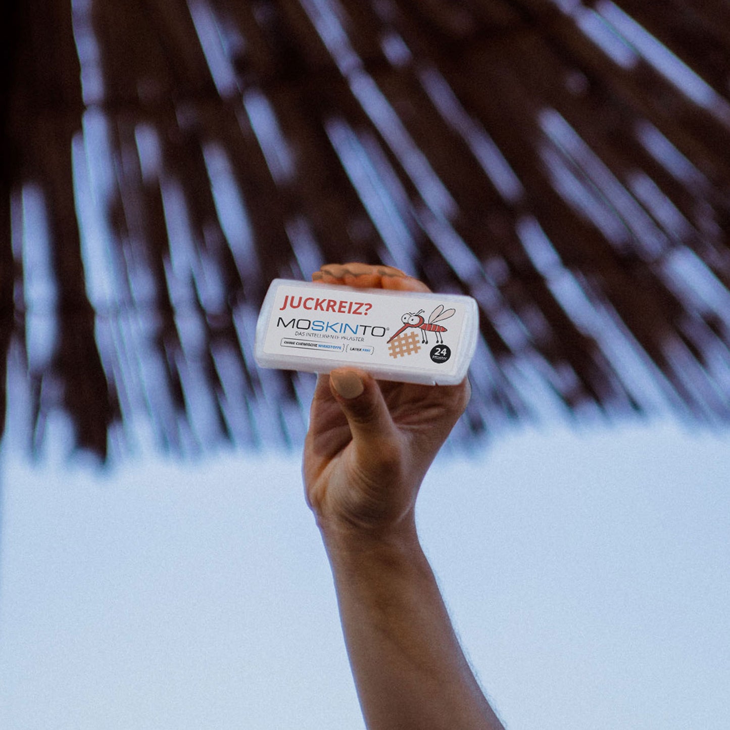 Moskinto Schiebebox in der Hand einer Frau im Urlaub am Strand.